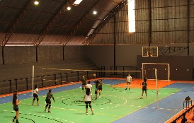 Ginásio de esportes coberto com alunos jogando