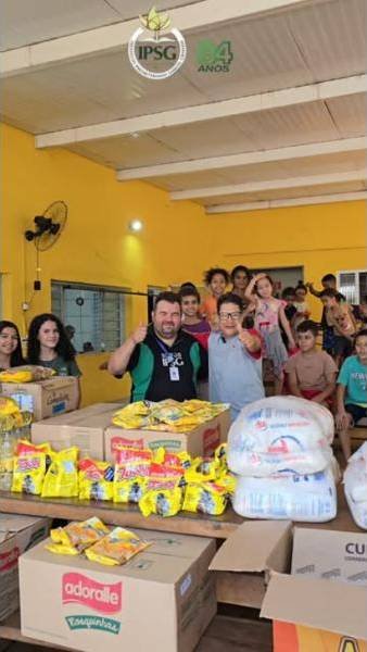Alunos e educadores ao lado de alimentos arrecadados