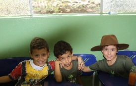 Três colegas de turma sorrindo em sala